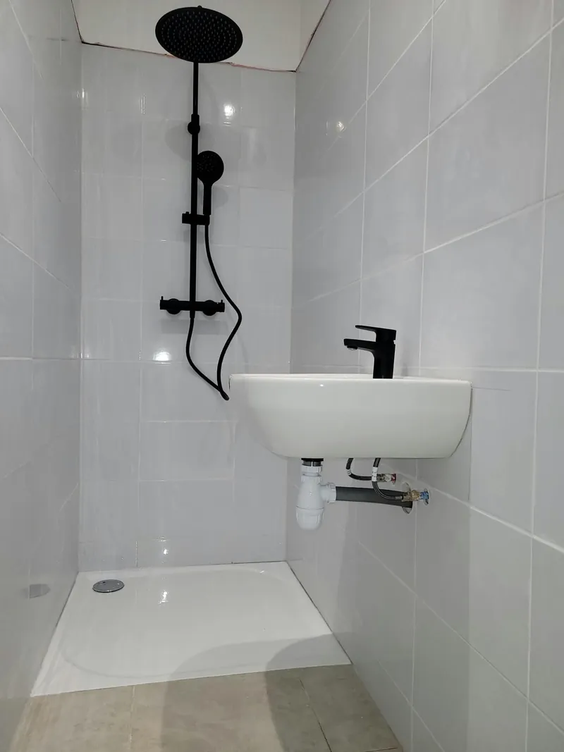 Salle d’eau compacte : receveur extra-plat, lavabo et colonne de douche noir mat